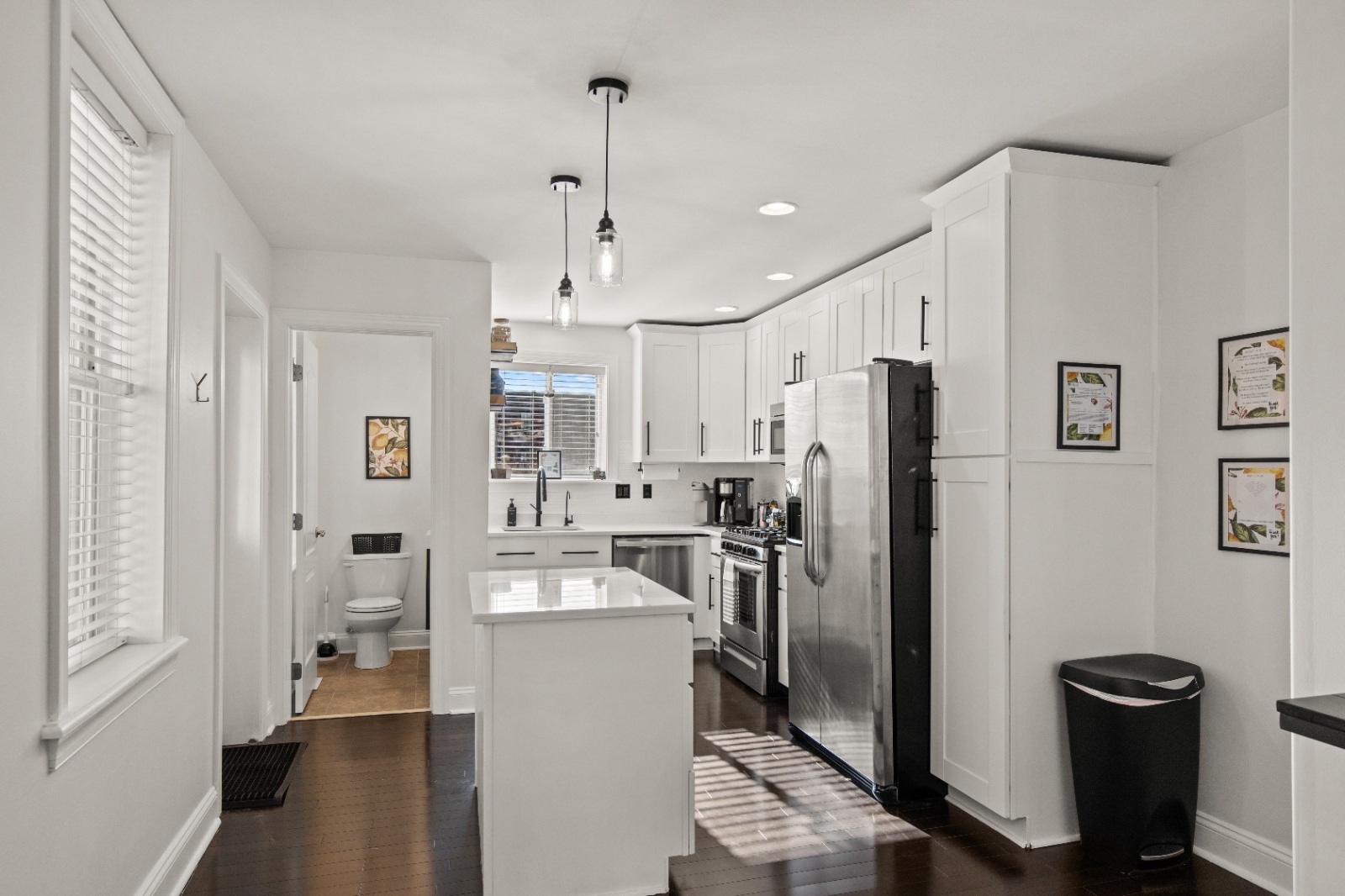 Bright white kitchen at Luxury on Lemon Airbnb in Lancaster, PA with stainless steel appliances, island seating, and modern finishes ideal for group stays.