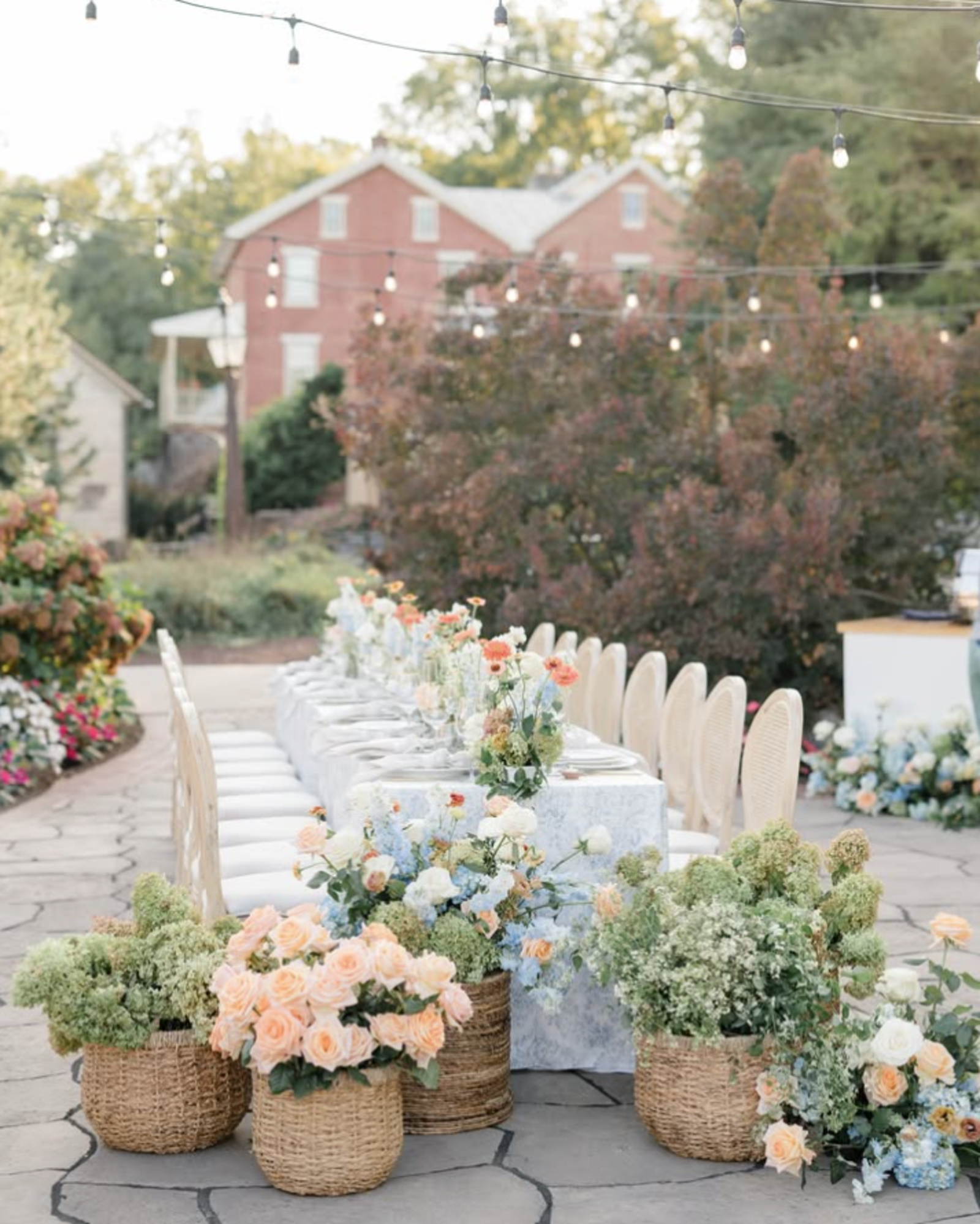 Outdoor garden wedding reception table with pastel flowers and string lights at Historic Acres of Hershey in Pennsylvania