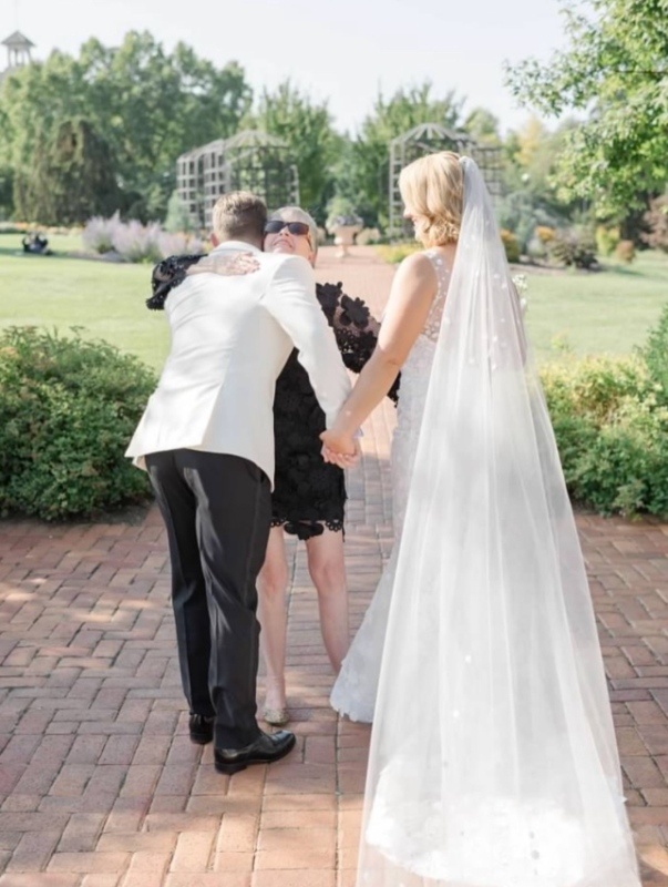 Susan Moran with Couple Groom and bride hugging wedding planner, Susan Moran.