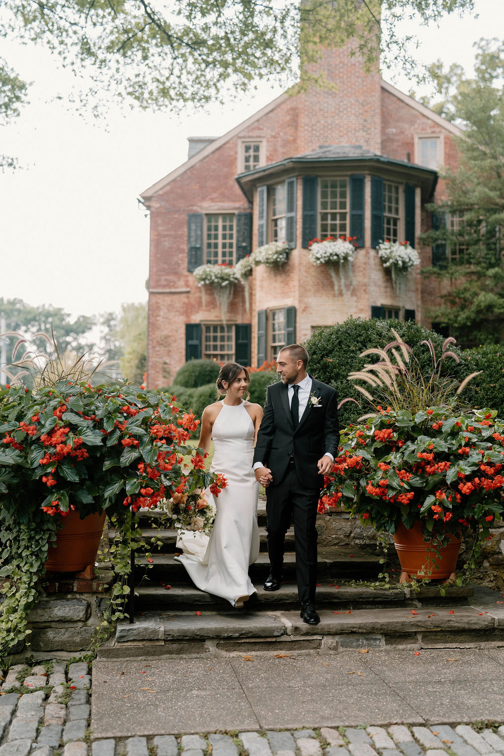 Bride and groom walking through the gardens at Conestoga House and Gardens wedding venue in Lancaster Pennsylvania