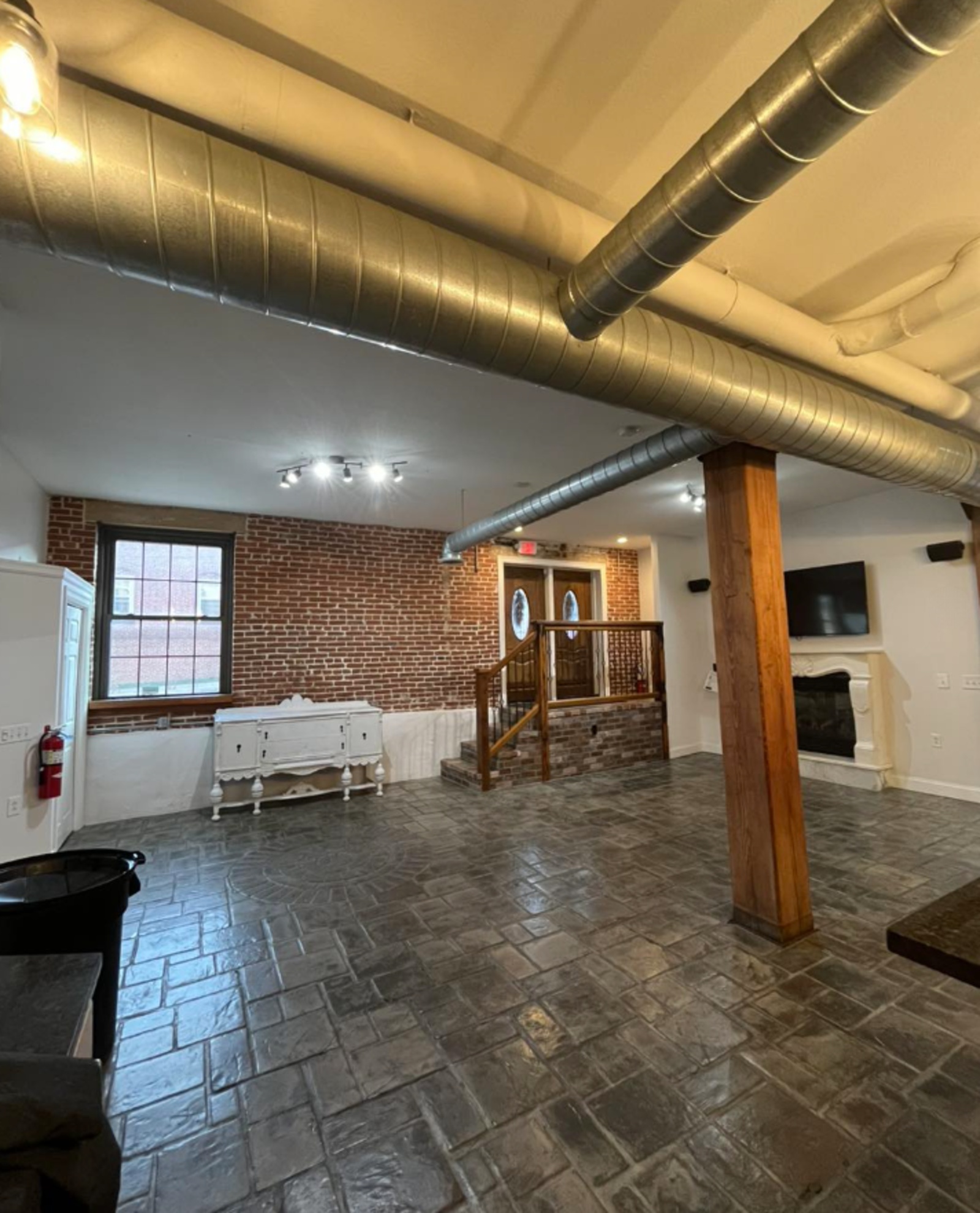 The Liberty Venue Industrial Wedding Space in Lancaster, PA Industrial event space at The Liberty Venue in Lancaster, PA, featuring exposed brick walls, wooden columns, and visible ductwork.