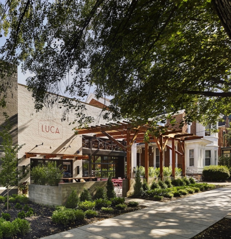 LUCA Restaurant in Lancaster, PA Exterior of LUCA restaurant in Lancaster, PA, with outdoor patio seating, wooden pergolas, and landscaped greenery.