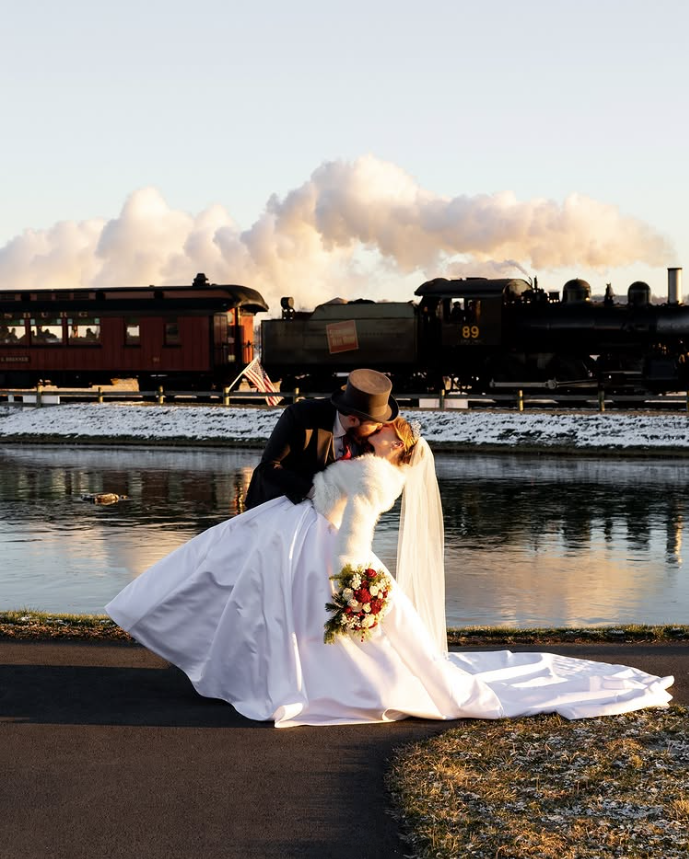 The Barn at Paradise Station Wedding Photos Newlyweds kissing beside the Strasburg Rail Road at The Barn at Paradise Station in Ronks, Pennsylvania