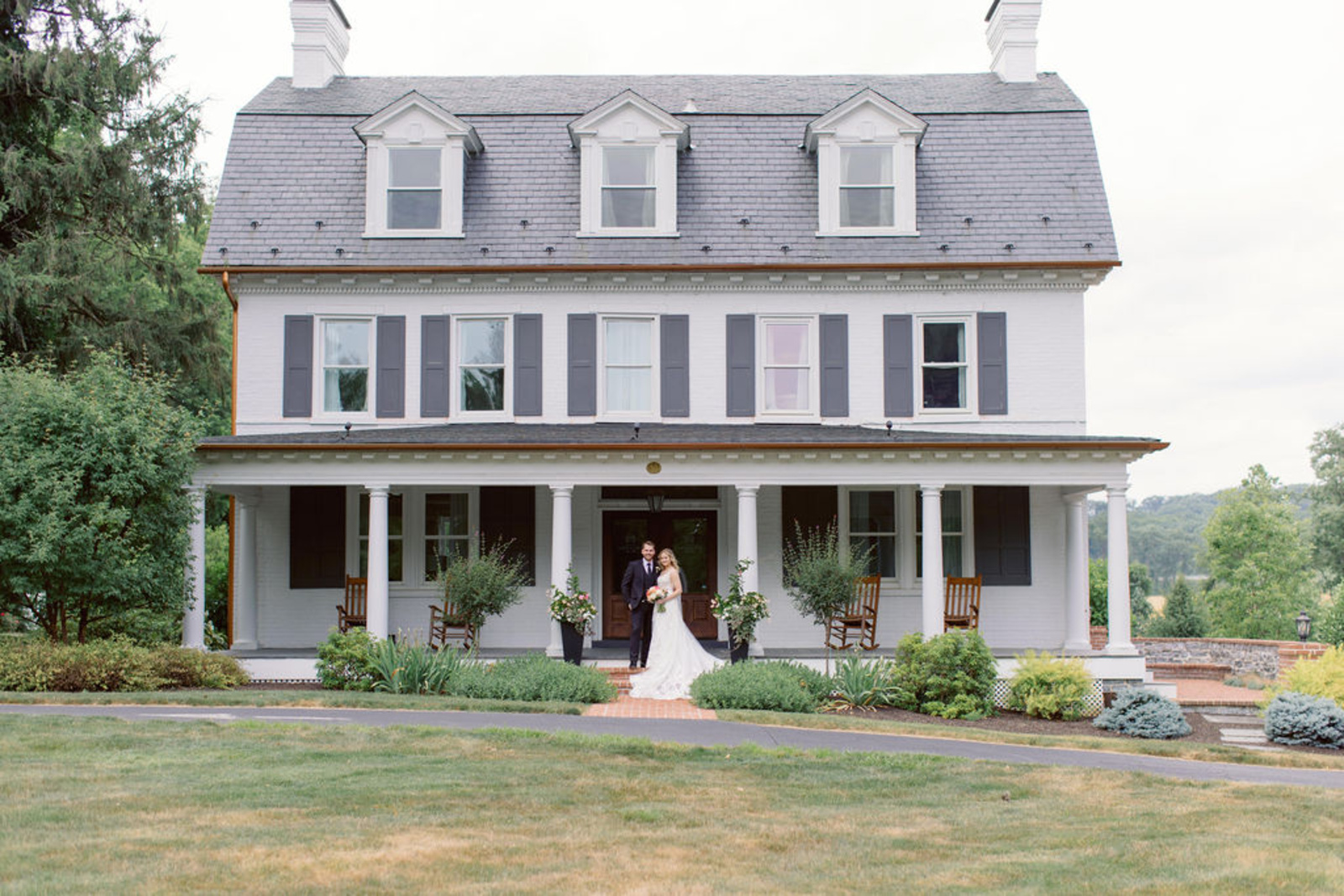 Historic Ashland Wedding Portrait Bride and groom standing in front of Historic Ashland’s white estate home during their romantic early summer wedding in Pennsylvania.