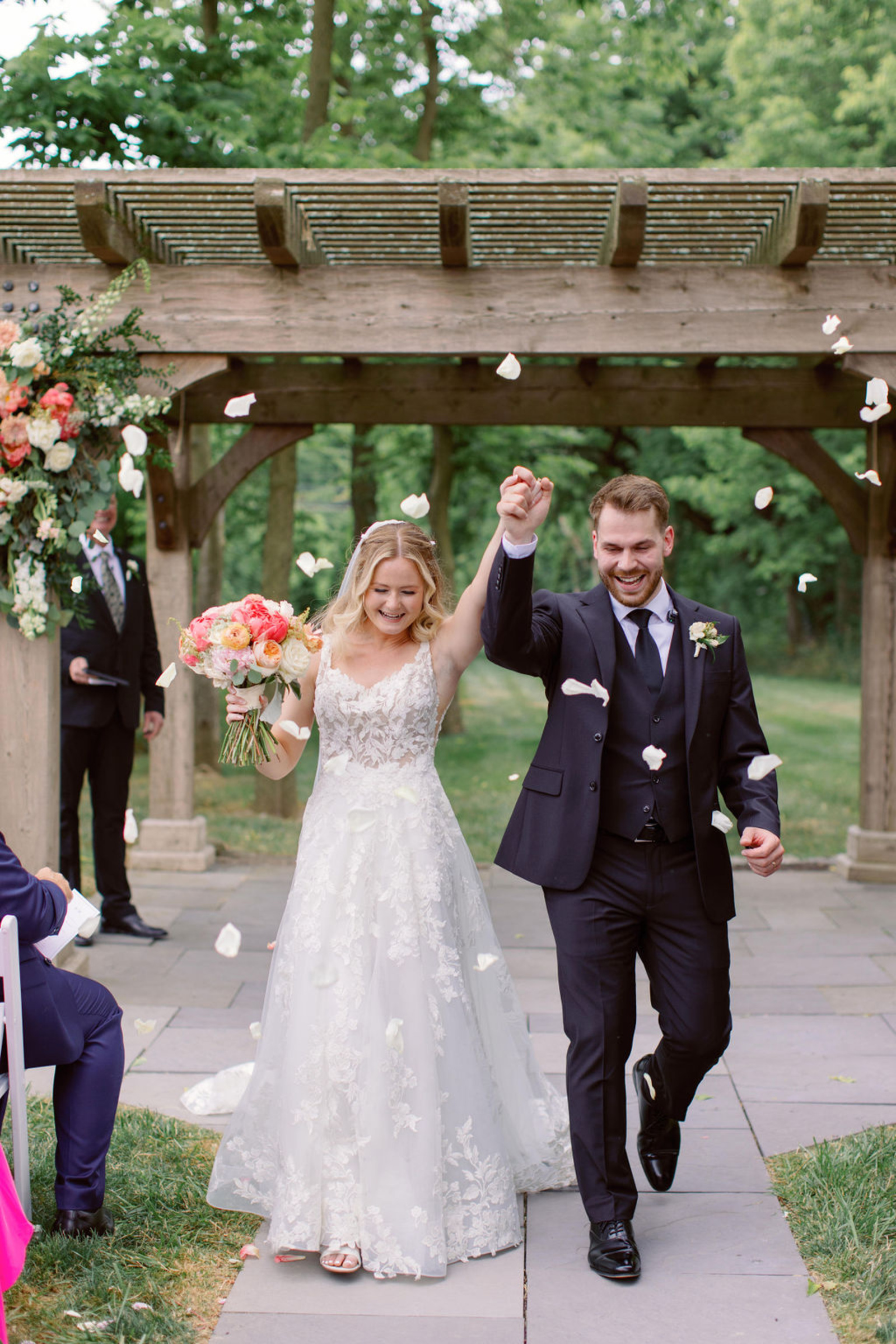 Bride and Groom Ceremony Recessional at Historic Ashland Bride and groom walking back down the aisle after their outdoor ceremony at Historic Ashland as guests toss flower petals around them.