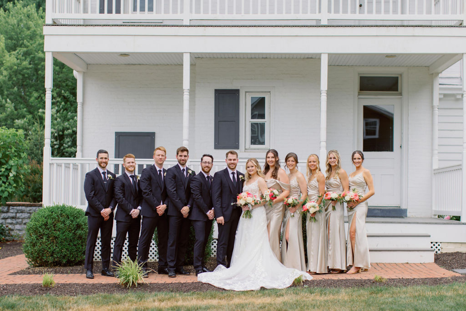 Wedding Party Portrait at Historic Ashland Bride and groom posing with bridesmaids in champagne dresses and groomsmen in navy tuxes outside Historic Ashland.