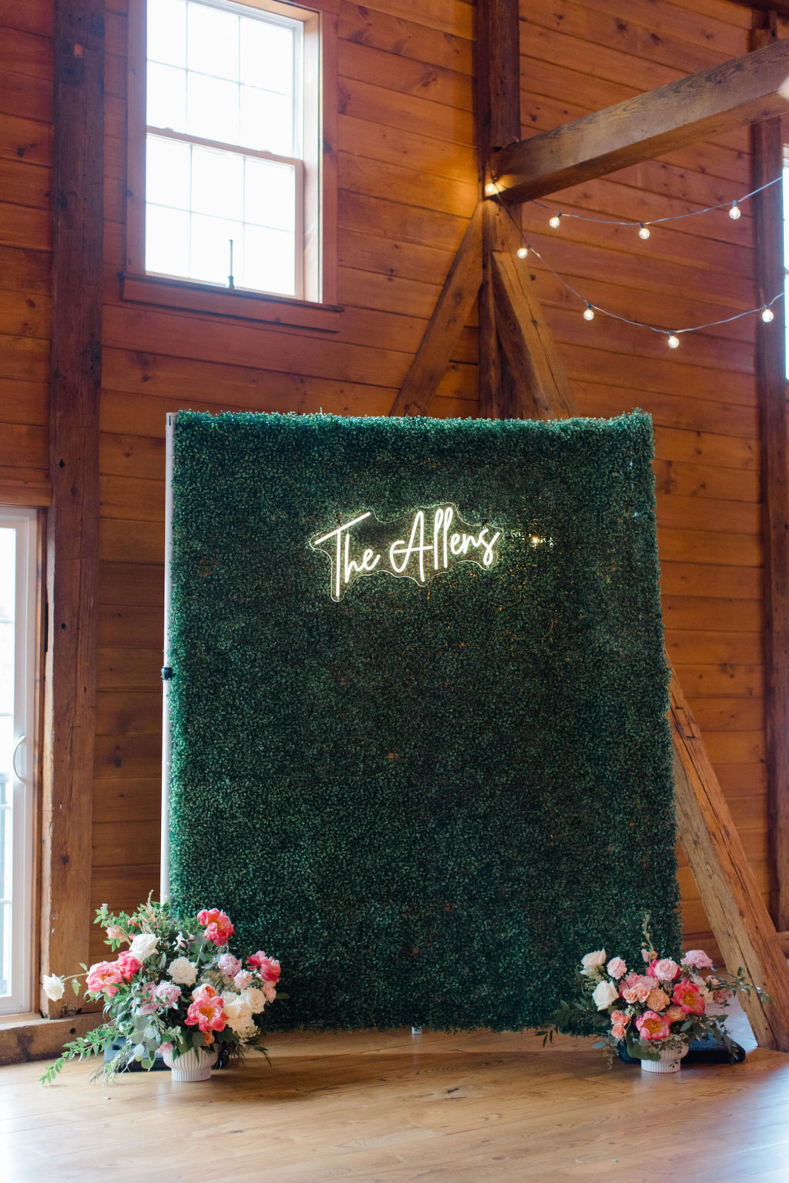 Wedding Photo Backdrop at Historic Ashland Green hedge wall with neon “The Allens” sign and bright summer florals inside Historic Ashland’s reception barn.