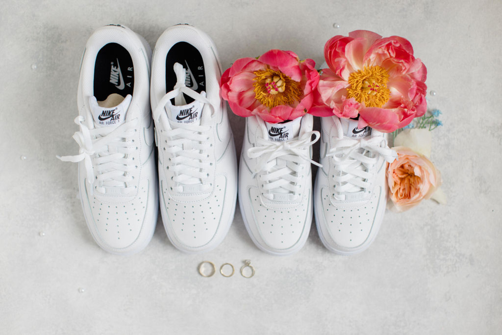 Bridal Nike Sneakers Styled with Summer Wedding Florals White Nike Air Force 1 sneakers styled with coral and peach florals alongside wedding rings for a romantic early summer wedding at Historic Ashland.