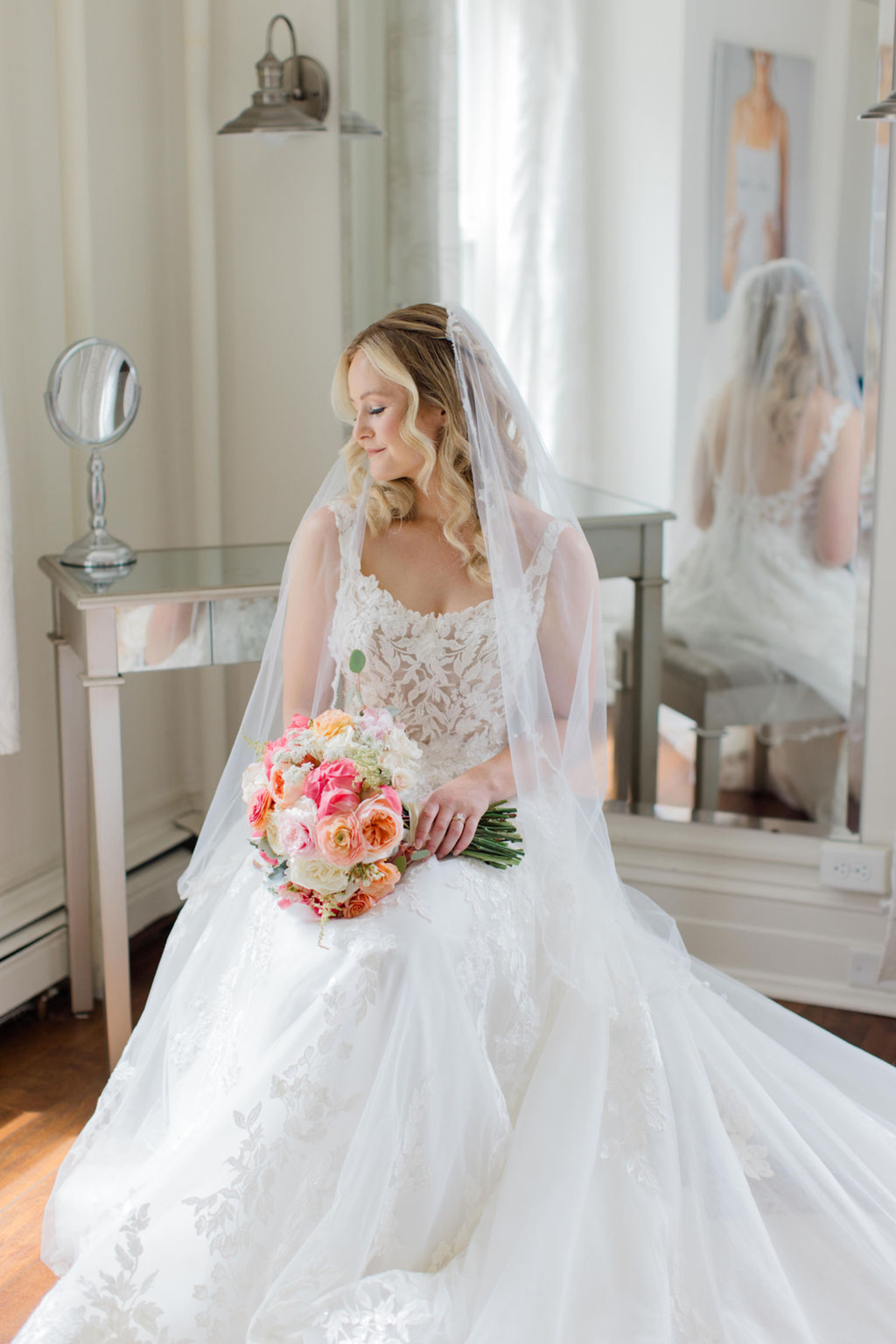 Bride Portrait at Historic Ashland Bride sitting in her lace wedding gown holding a coral and blush bouquet inside Historic Ashland during getting-ready moments before the ceremony.