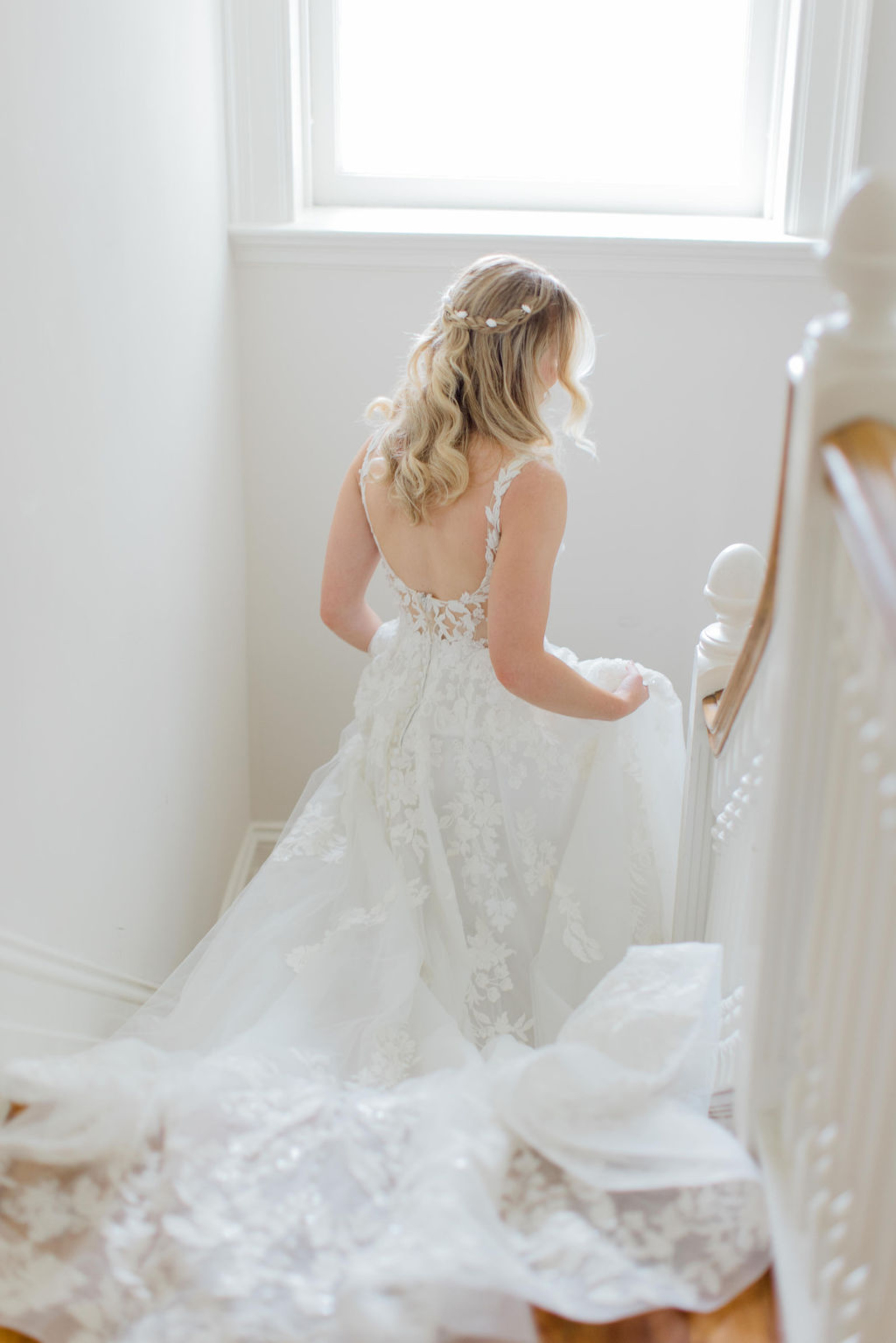 Bride Walking Down Staircase at Historic Ashland Bride in a floral lace wedding gown walking down the staircase inside Historic Ashland before her early summer wedding ceremony.