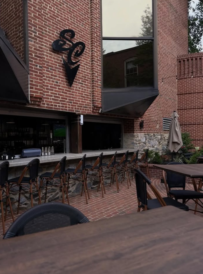 South County Brewing Co. Outdoor Patio in Lancaster, PA Outdoor patio at South County Brewing Co. in Lancaster, PA, with bar seating, high-top tables, brick walls, and open-air dining.