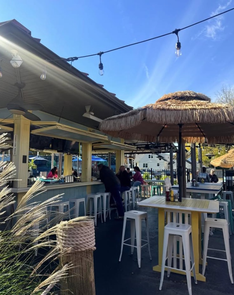 Tobias Frogg Outdoor Patio in Lancaster, PA Outdoor patio at Tobias Frogg in Lancaster, PA, with bar seating, high-top tables, string lights, and tropical-style umbrellas.
