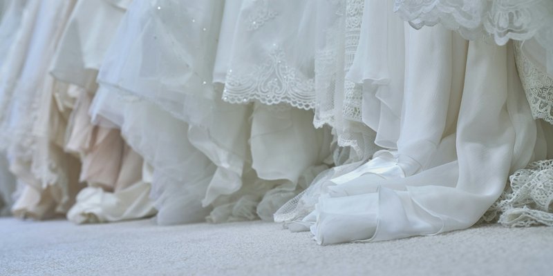 Wedding dresses hanging in a Central PA bridal boutique with lace and flowing fabric details