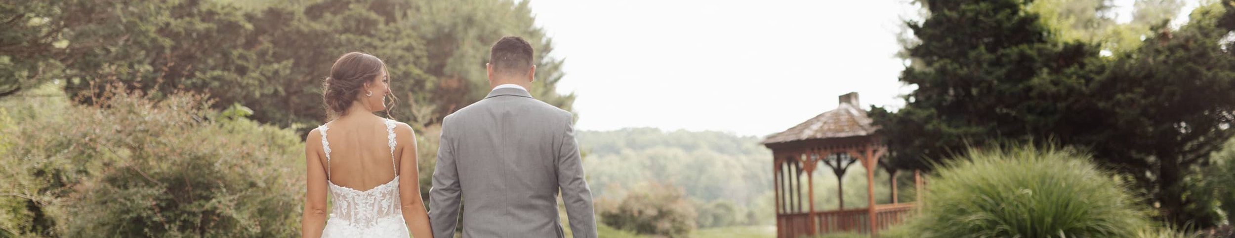 wedding couple walking to a gazebo and smiling