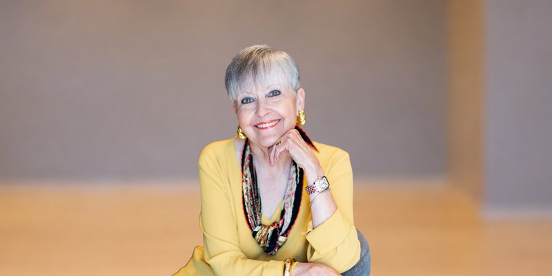 Bride and groom kissing surrounded by joyful loved ones