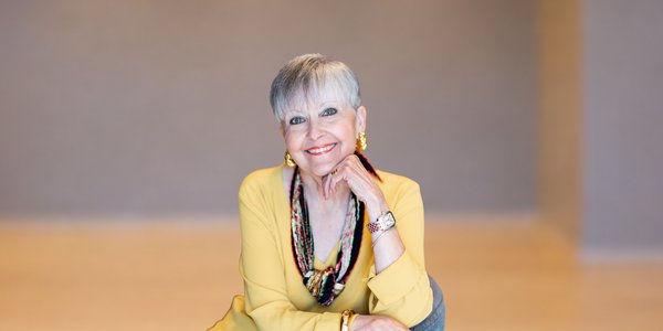 Bride and groom kissing surrounded by joyful loved ones